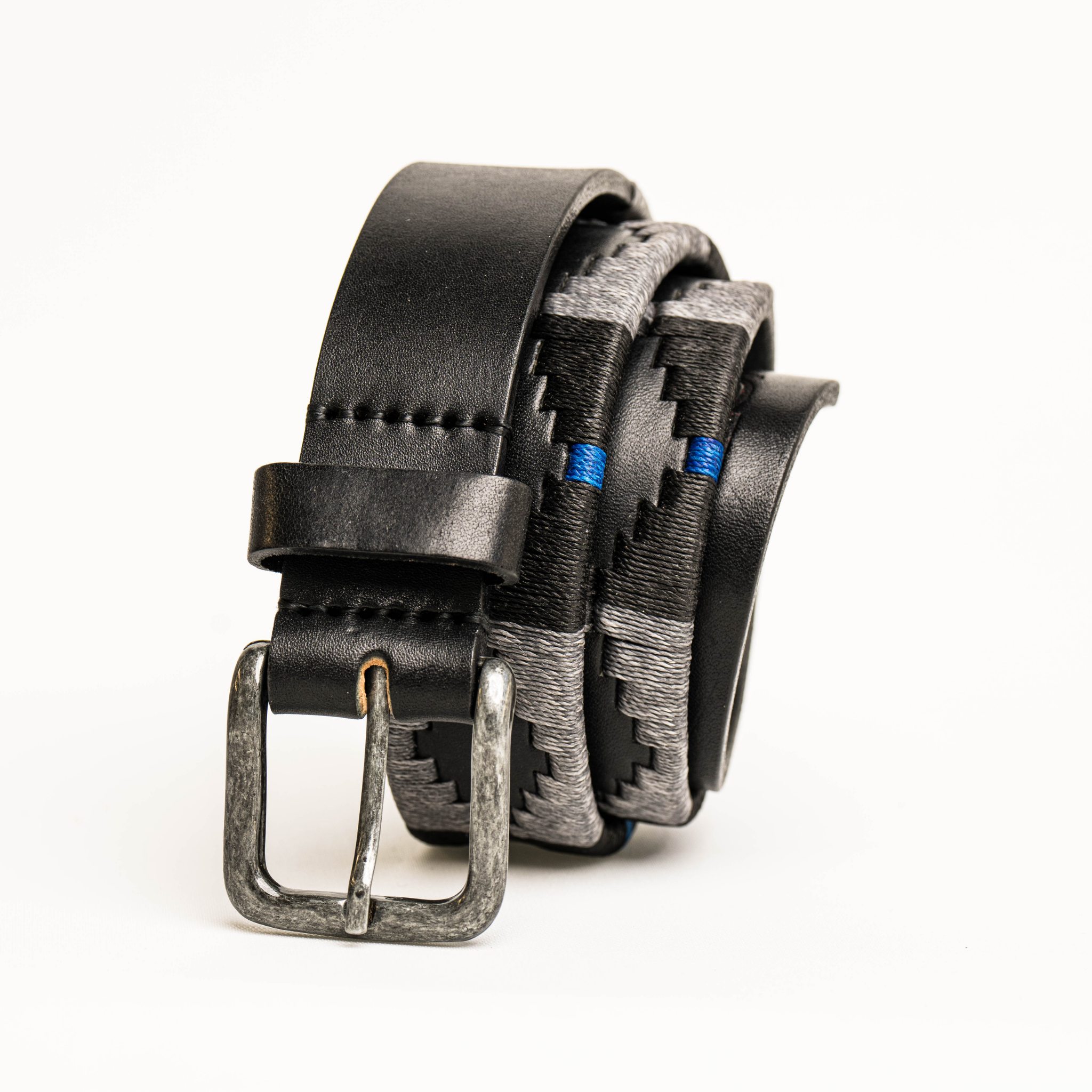 Close-up highlighting the buckle of the Country Direct & Pampeano Police - REORG Leather Polo Belt, featuring black leather, with grey, black, and blue wax thread detailing. 